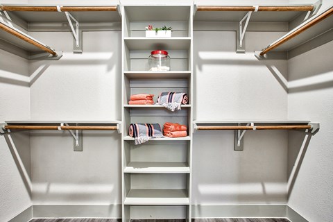 A kitchen pantry with a white wall and a white fridge with a shelf and a drawer.