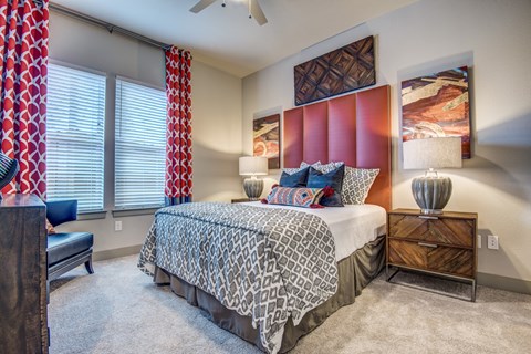 A bedroom with a bed, a chair, and a painting on the wall.