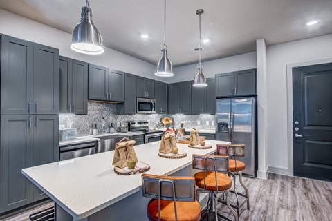 A modern kitchen with a white countertop and grey cabinets.