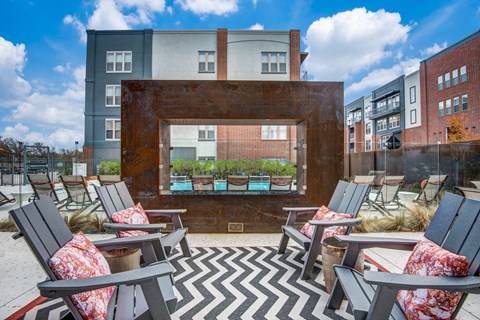 A patio with chairs and a table with a view of a building.