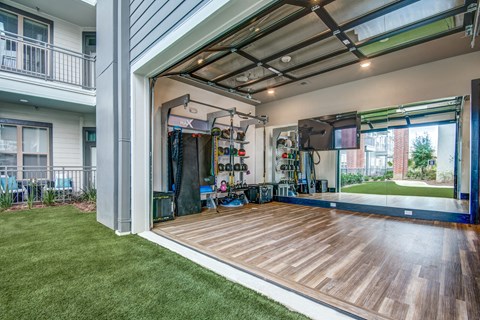 A garage with a gym inside is attached to a house.
