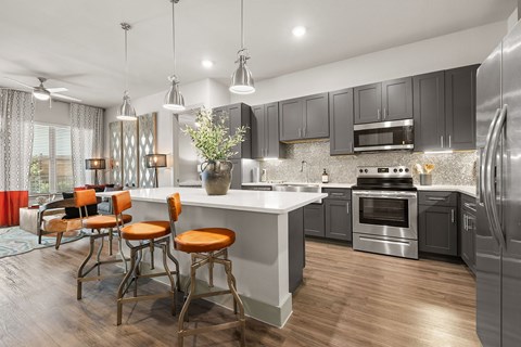 A modern kitchen with a bar area and a dining table.