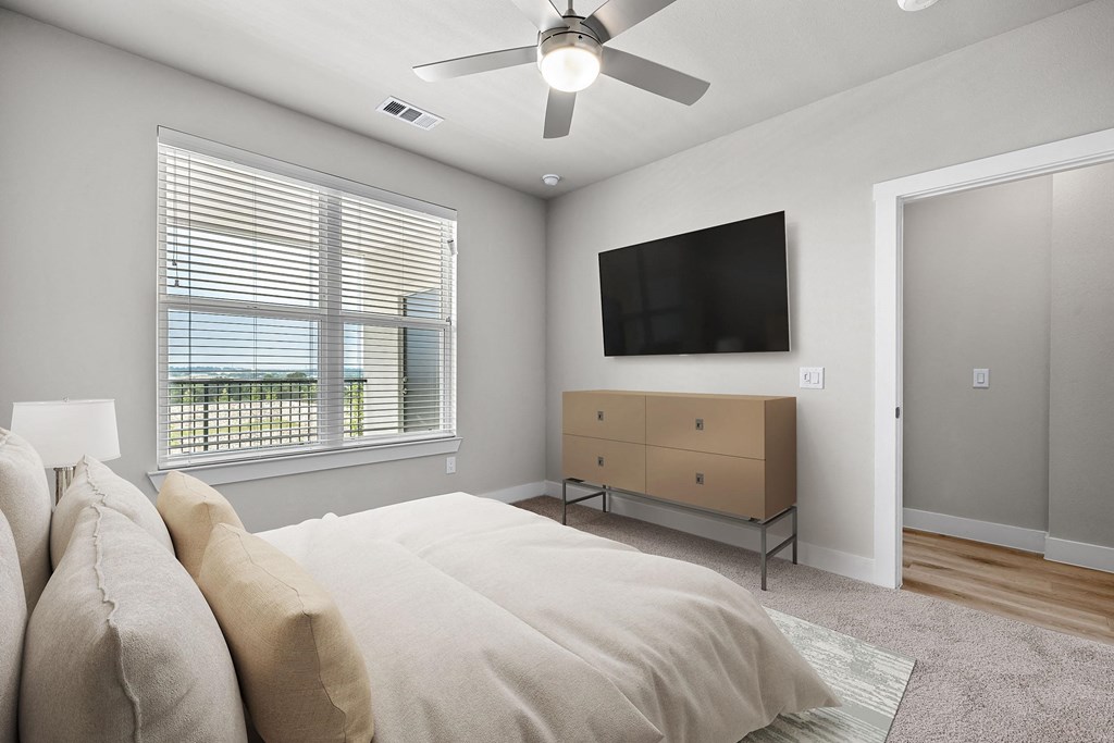 a bedroom with a large bed and a ceiling fan
