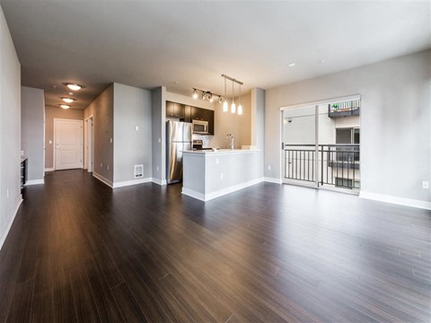 A spacious room with wooden floors and white walls.