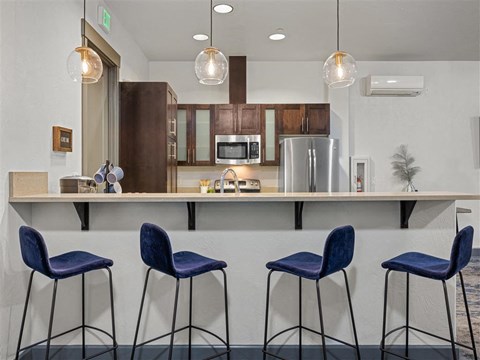 a kitchen with a counter with three stools