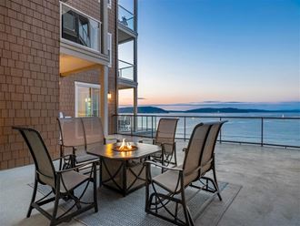 a patio with chairs and a table overlooking the water