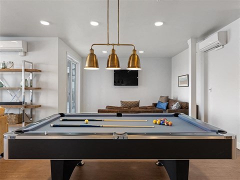 a pool table in a living room with a tv