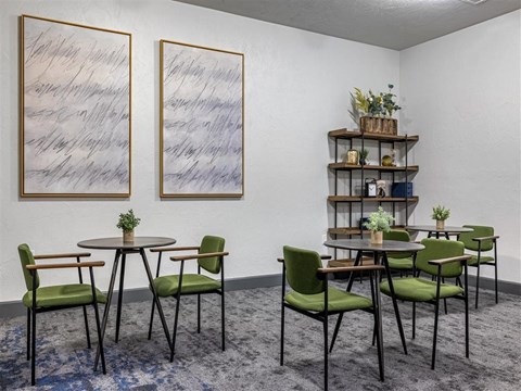 a dining room with tables and chairs and paintings on the wall