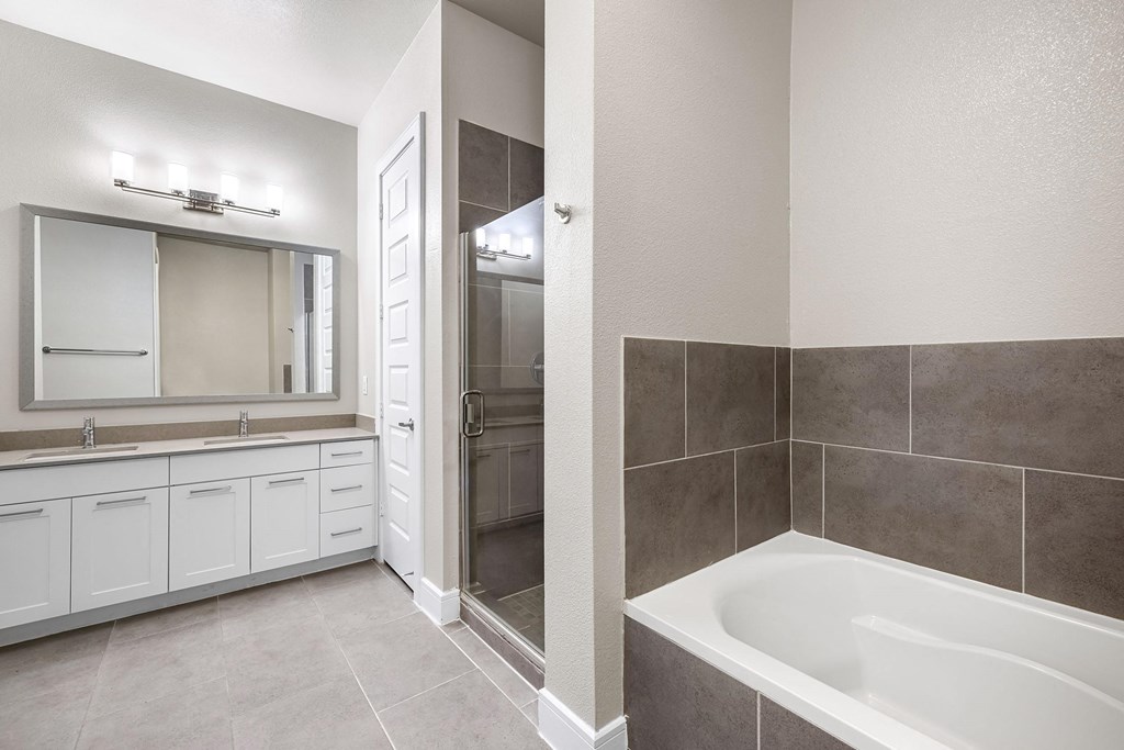 a bathroom with a tub and a shower and a sink