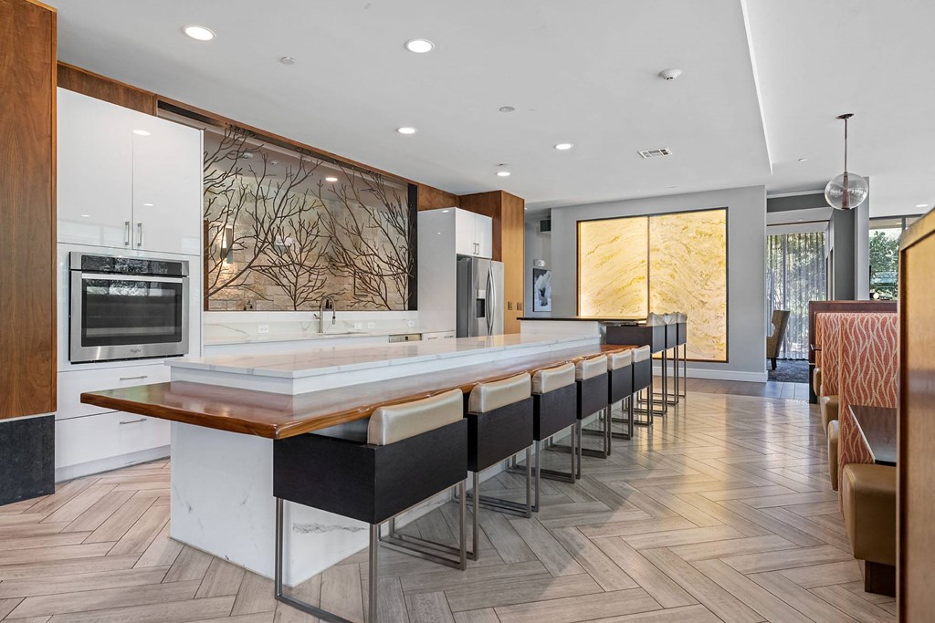 a large kitchen with a long bar and wooden floors