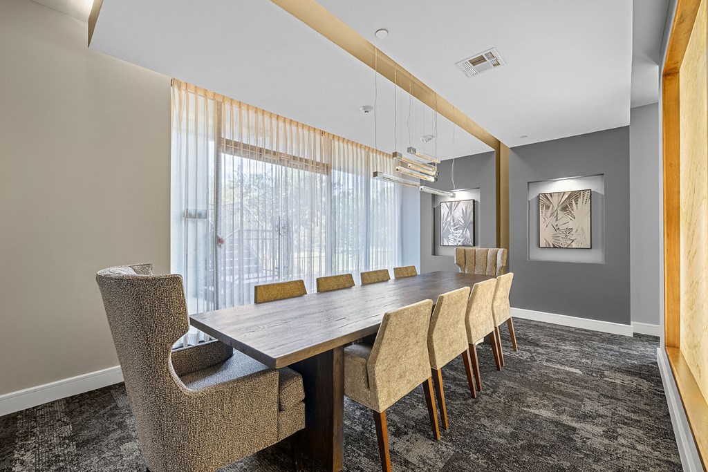 a dining room with a long wooden table and chairs