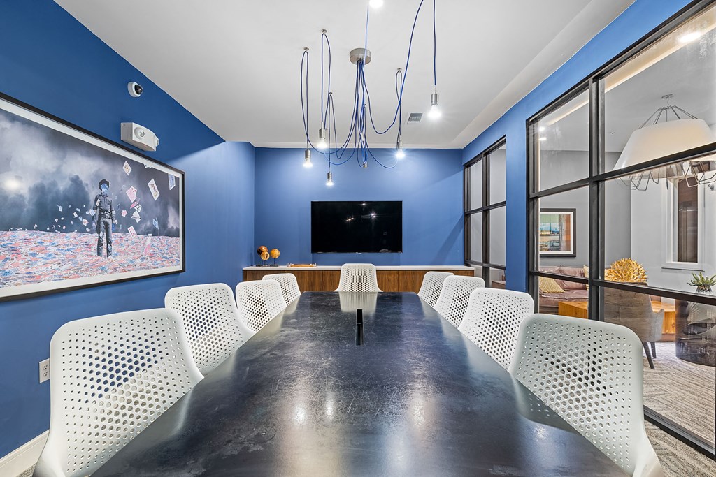 a conference room with a long table and chairs and a tv on the wall