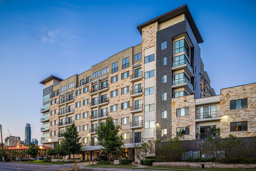 a large apartment building with a blue sky in the background