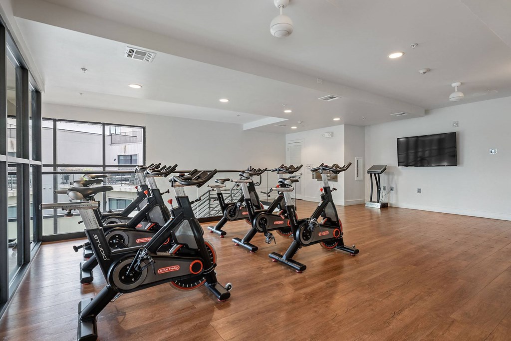 a gym with cardio bikes and a tv on the wall