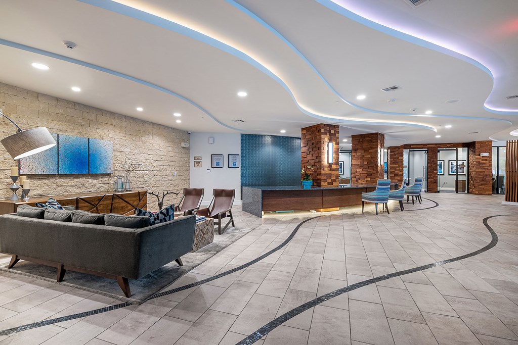the lobby of a hotel with a couch and chairs