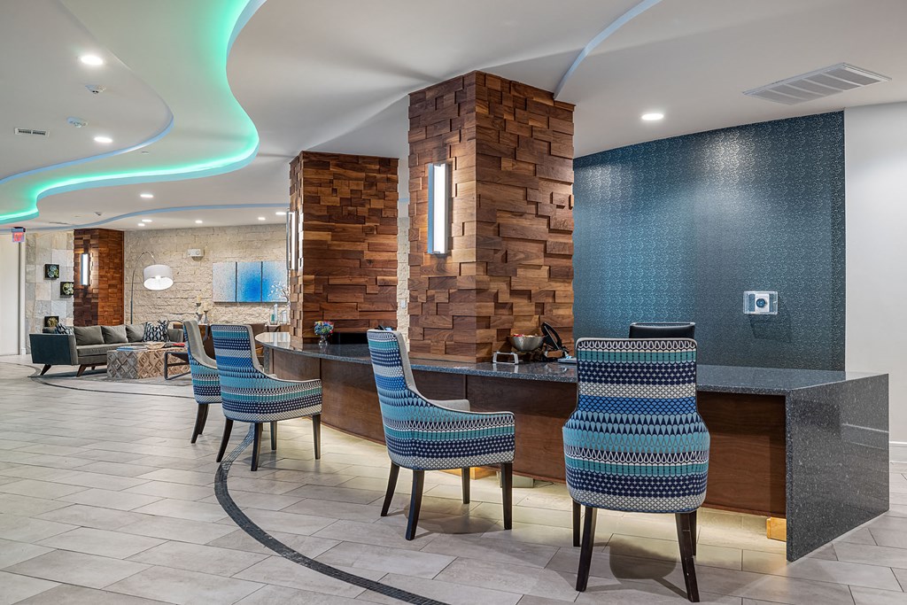 a lobby with chairs and a bar with a stone pillar