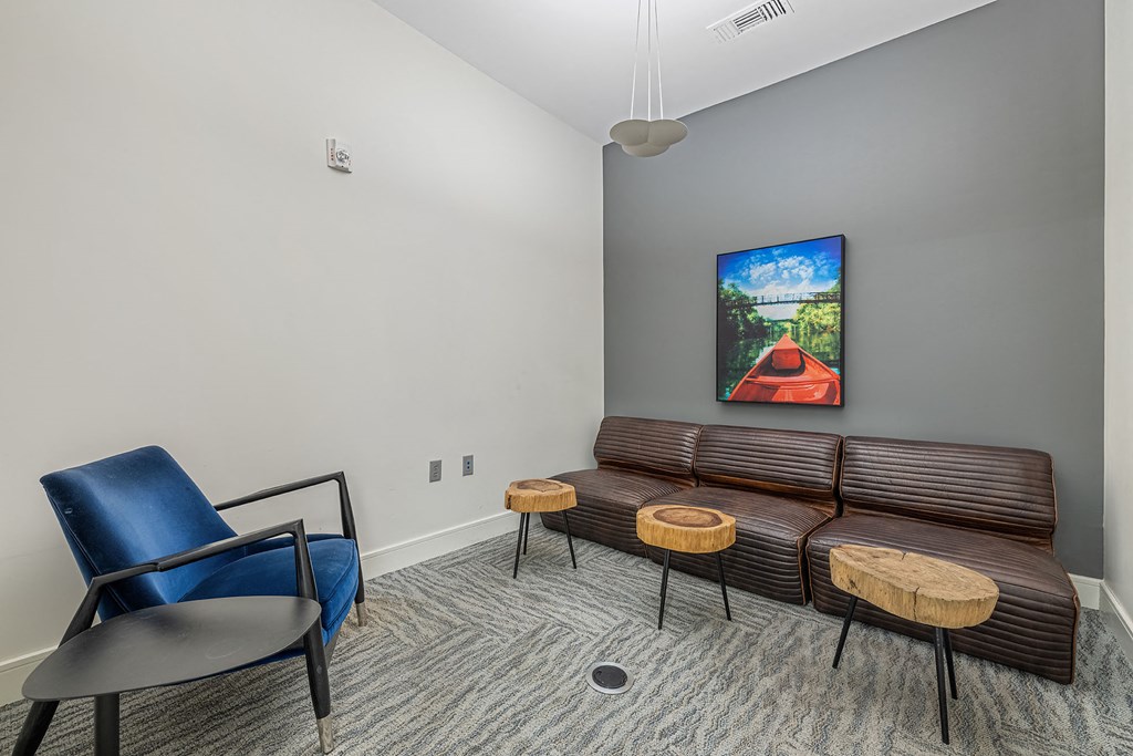 a living room with couches and chairs and a painting on the wall