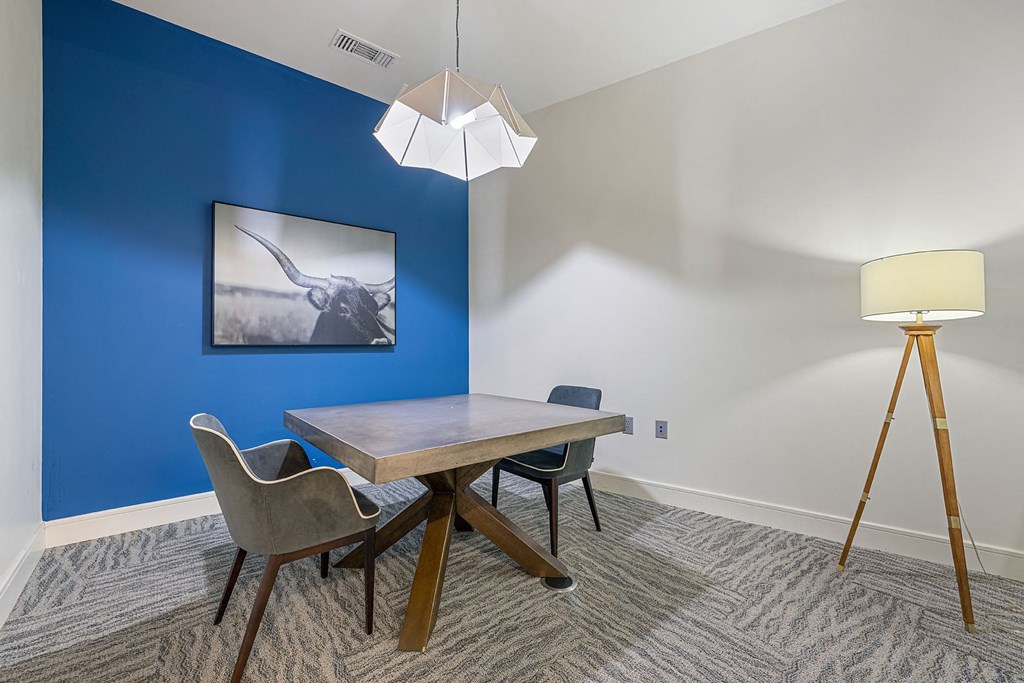 a dining room with a table and chairs and a blue wall
