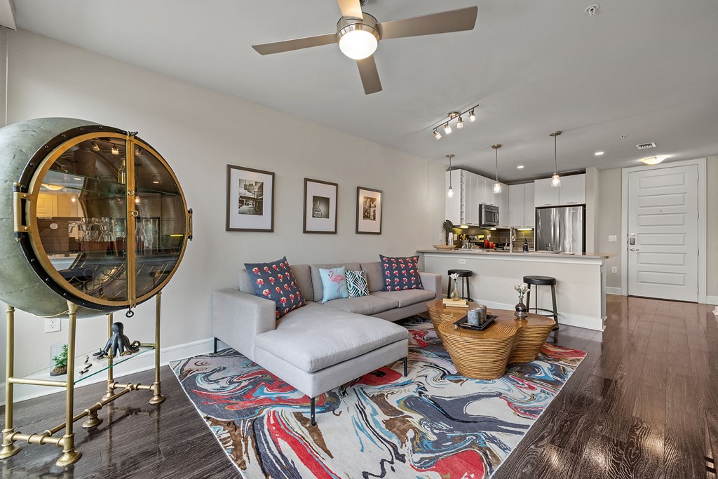 a living room with a couch and a chair and a mirror