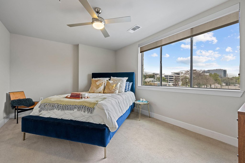 a bedroom with a large window and a bed
