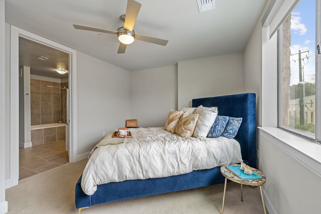 a bedroom with a bed and a ceiling fan