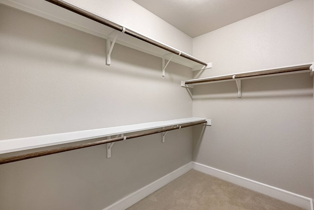 a spacious walk in closet with shelves and hanging racks