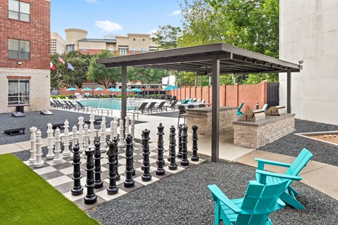 A giant chess set is set up on a patio.