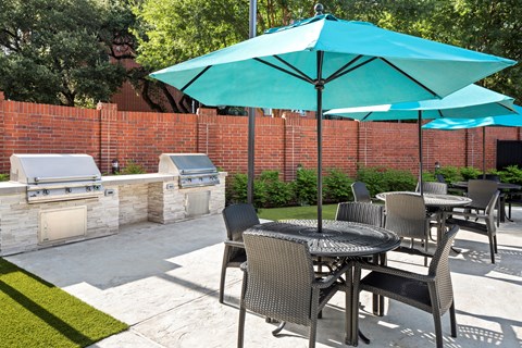 A patio with a table and chairs under a blue umbrella.