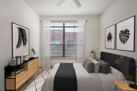 A bedroom with a bed, a ceiling fan, and two framed pictures on the wall.
