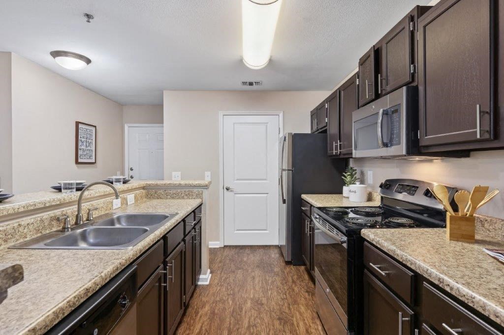 a kitchen with granite counter tops and black appliances