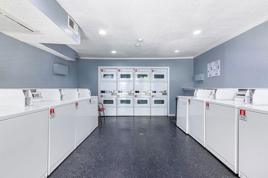 the laundry room has many washes and dryers in it