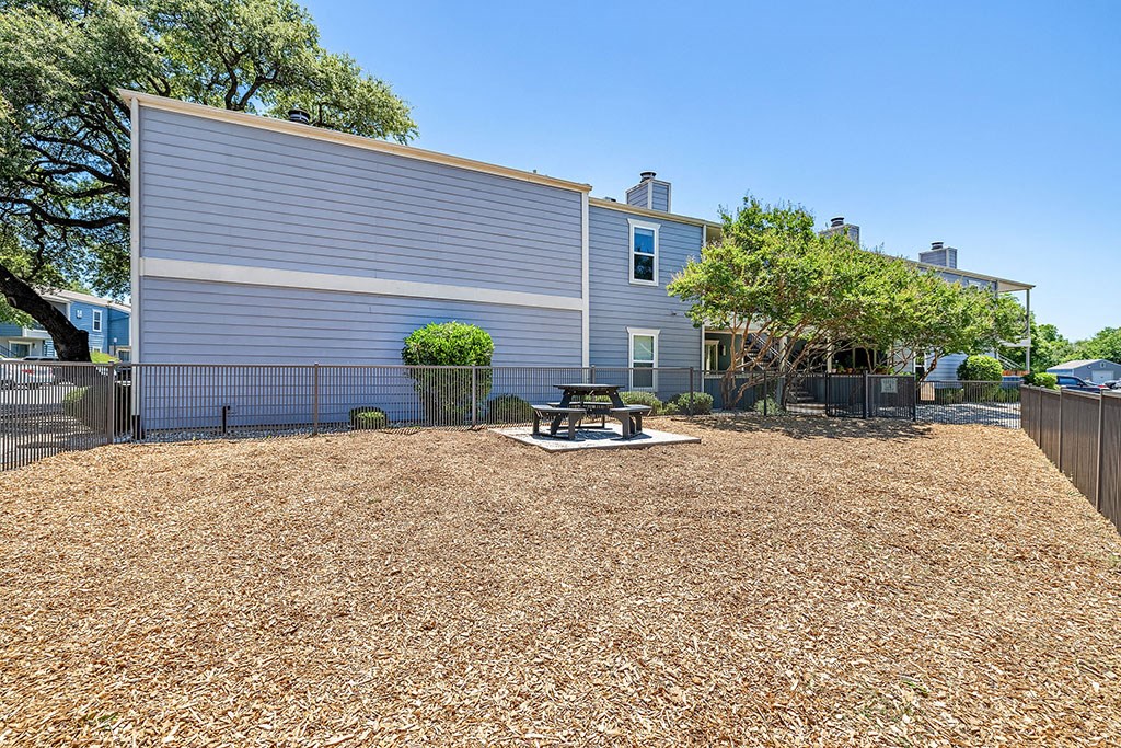 a yard with a picnic table in front of a house