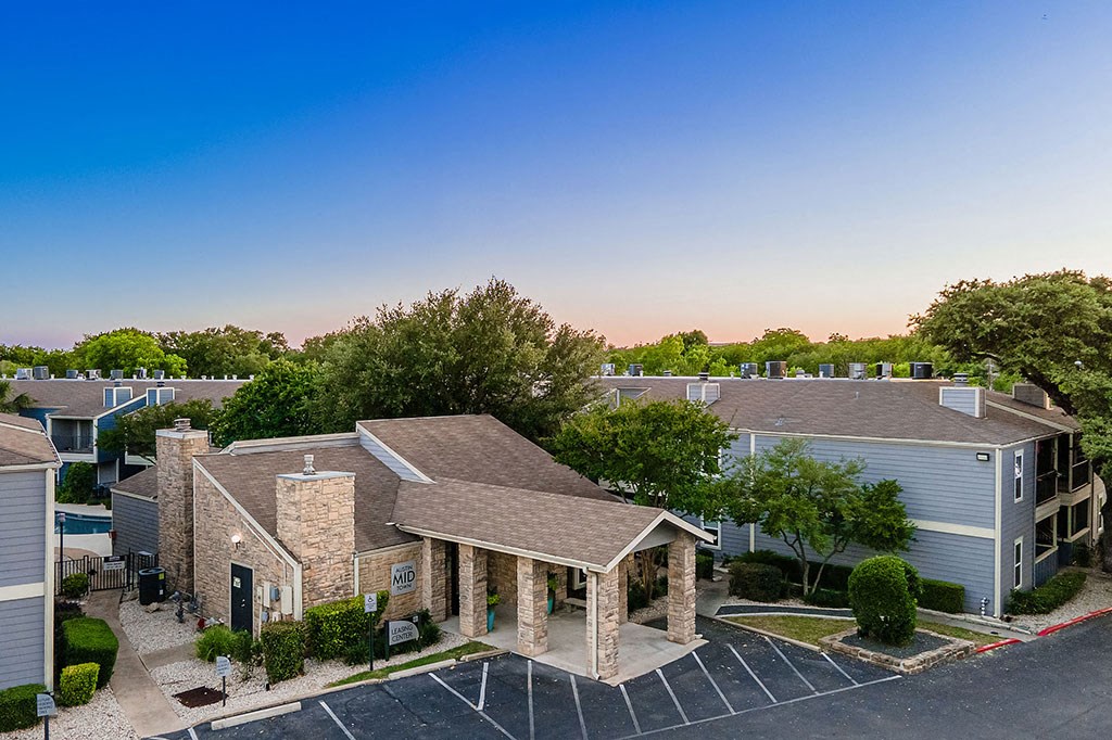 an aerial view of an apartment building with a parking lot