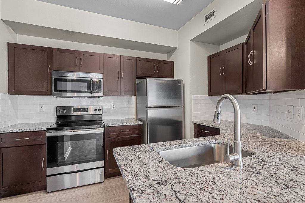 a kitchen with granite counter tops and stainless steel appliances