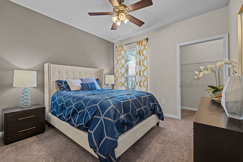 a bedroom with a bed and a ceiling fan