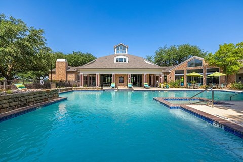 a large swimming pool with a house in the background