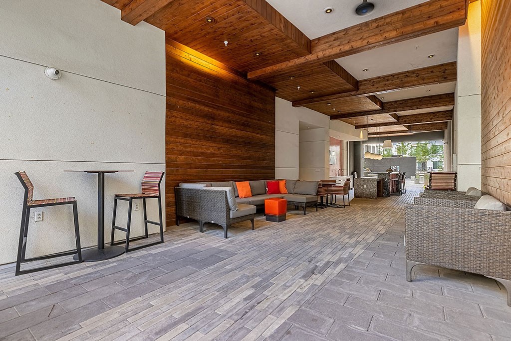 a large lobby with seating and tables and a wooden wall