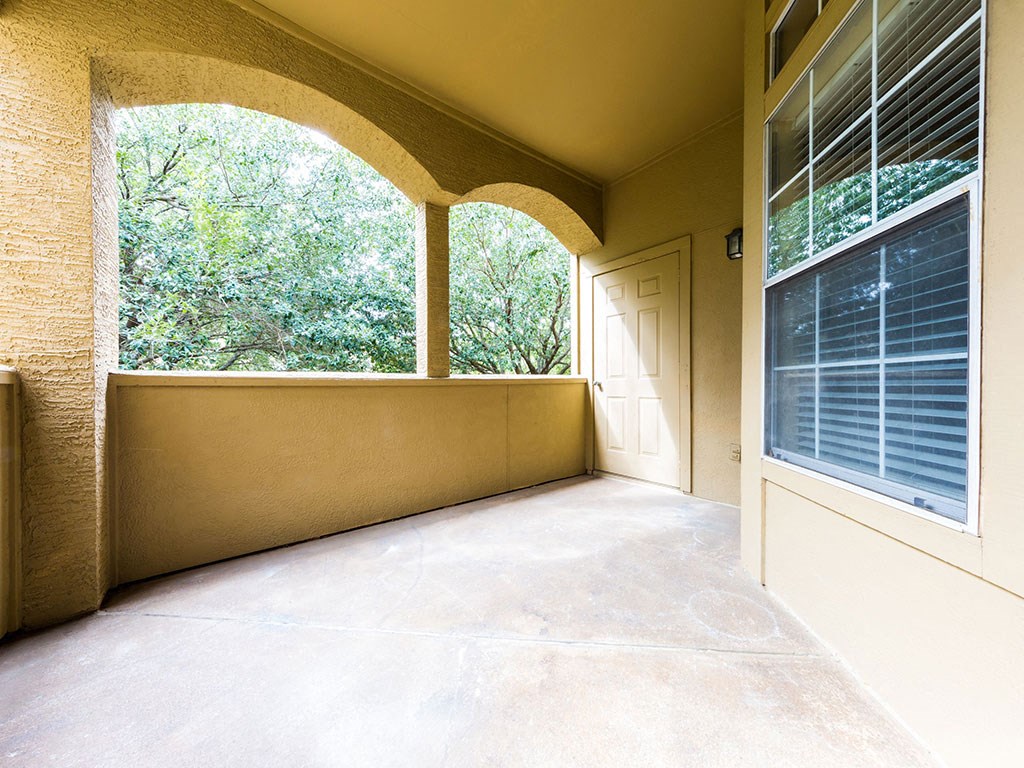 a covered porch with large windows and a door