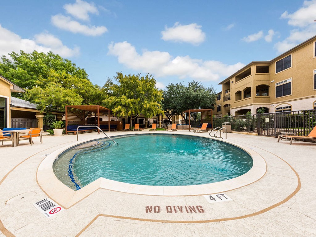 a resort style pool is in the middle of an apartment building