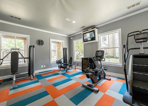a home gym with weights and a tv