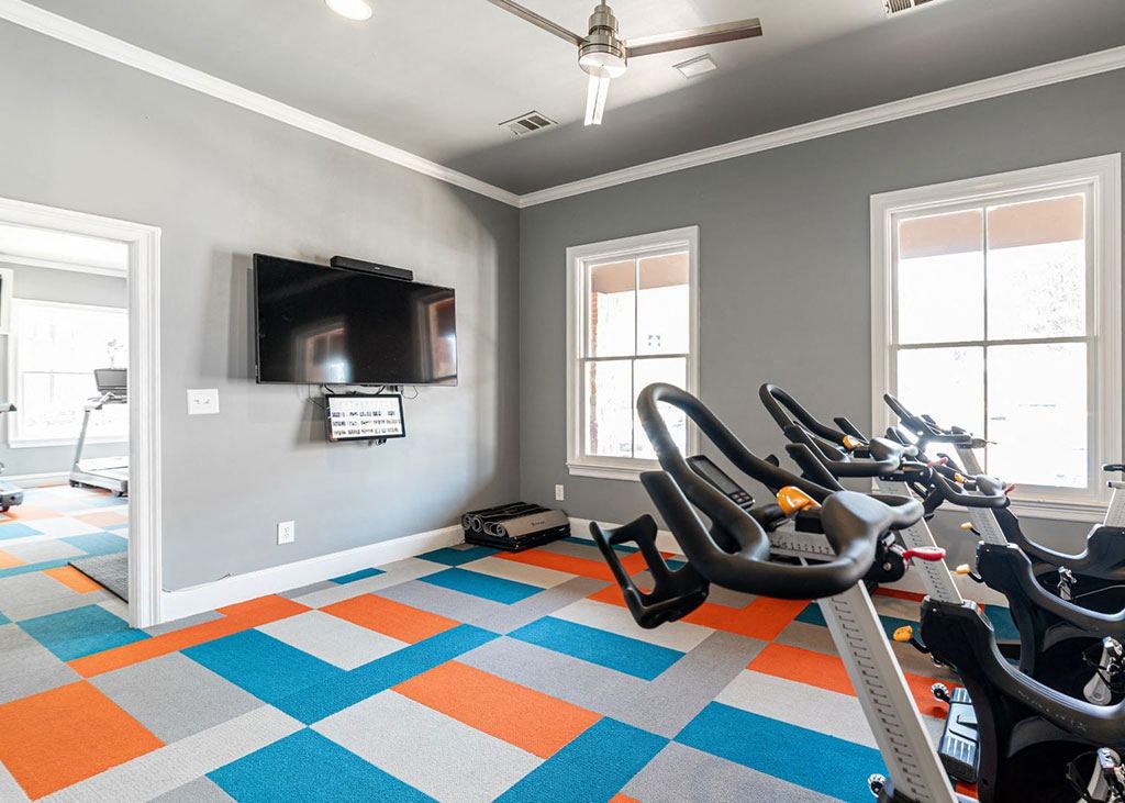 a home gym with exercise bikes and a tv