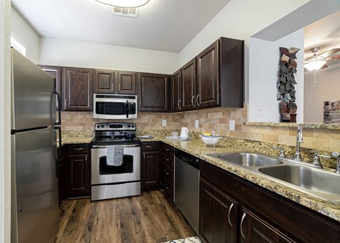 a kitchen with stainless steel appliances and granite counter tops