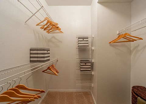 a walk in closet with shelves and hooks