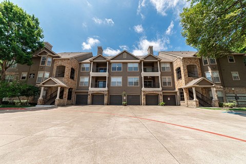 an empty parking lot in front of an apartment building