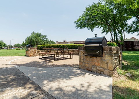 a patio with a grill and a picnic table