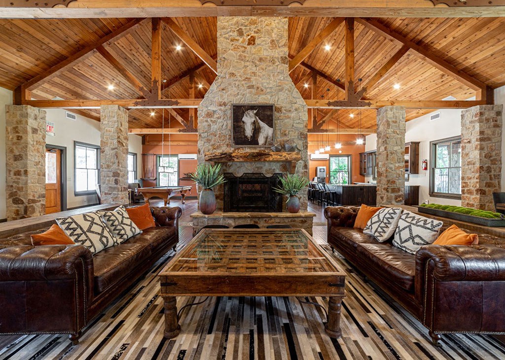 the living room has a large stone fireplace and leather couches