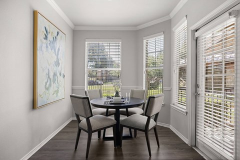 A dining room with a table and chairs.