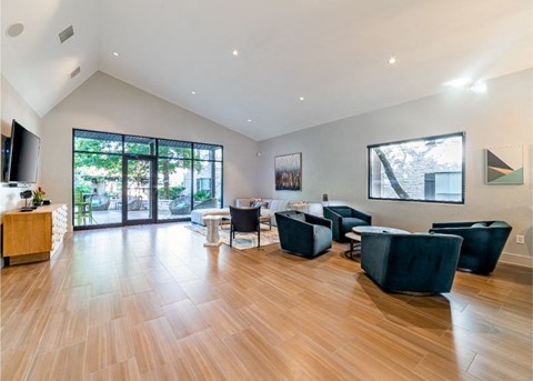 A living room with black furniture and wooden floors.