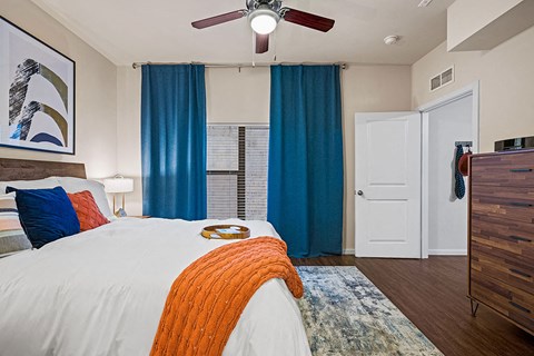 A bedroom with a white bed and a ceiling fan.
