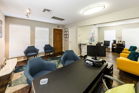 A conference room with a black table and blue chairs.